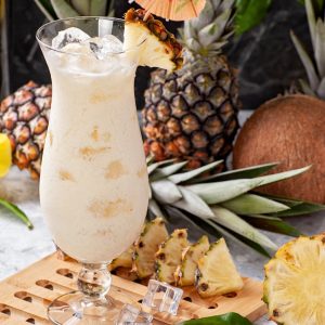 Delicious pina colada cocktail with tropical fruits and umbrella garnish.