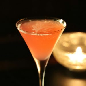 a glass of liquid and a candle